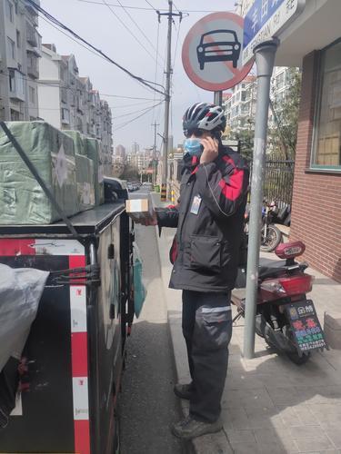 在青岛,一名顺丰快递员与小区居民电话沟通前来取件