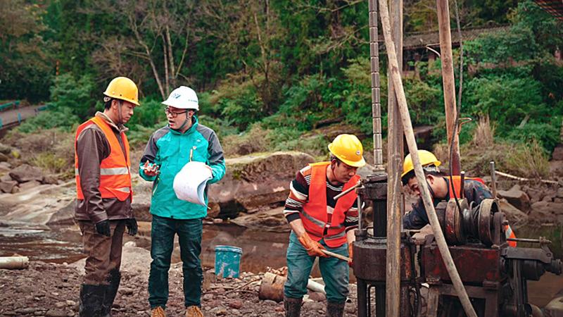 四川公路工程咨询监理有限公司勘察设计一院勘察人员在“铁索桥改公路桥项目”夹江县童口河桥勘察现场，给现场钻机机组人员进行安全技术交底.jpg