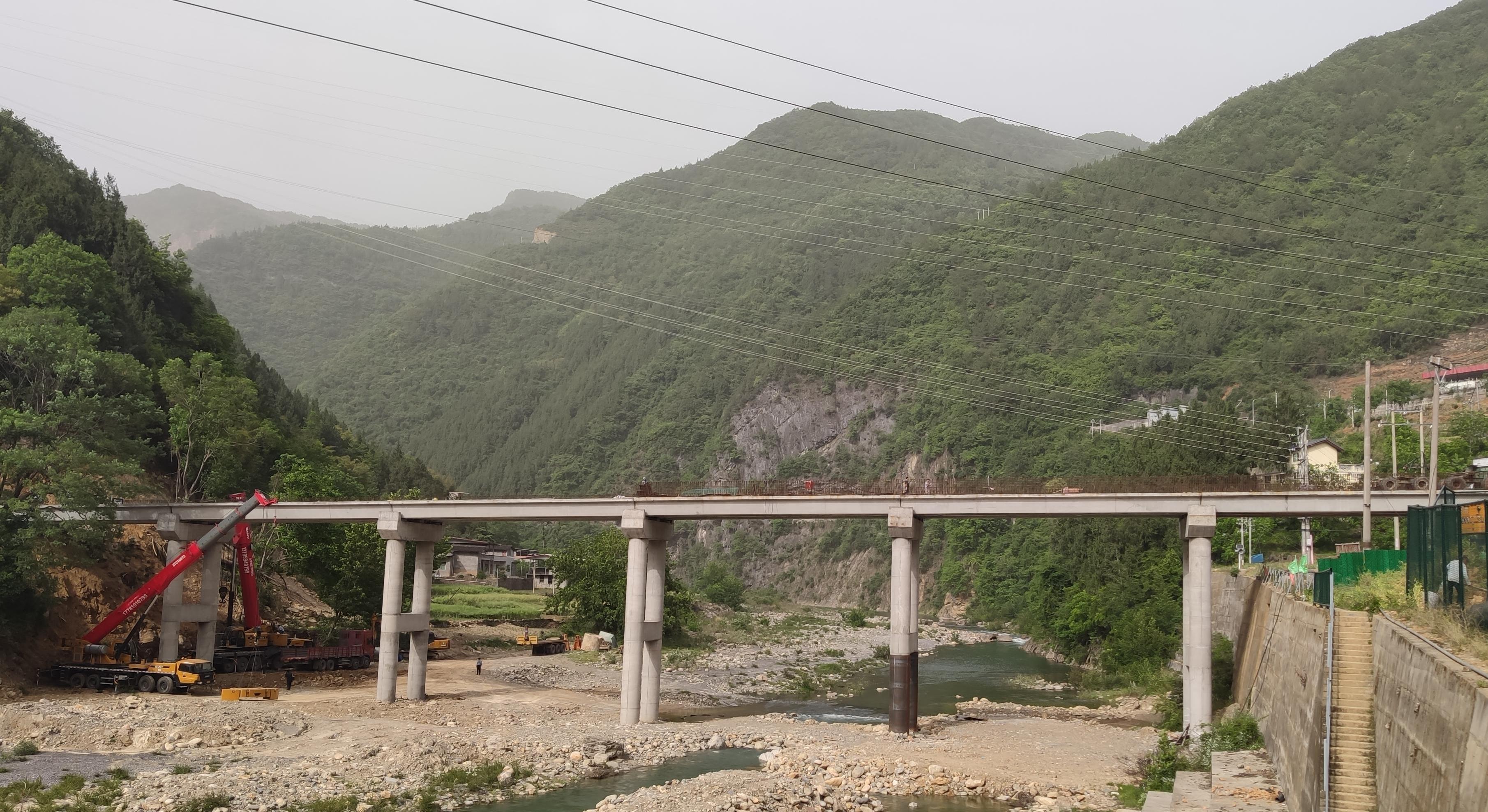 4月28日,南江县桥亭镇龙门村上坝铁索桥正在进行最后一跨预制梁片