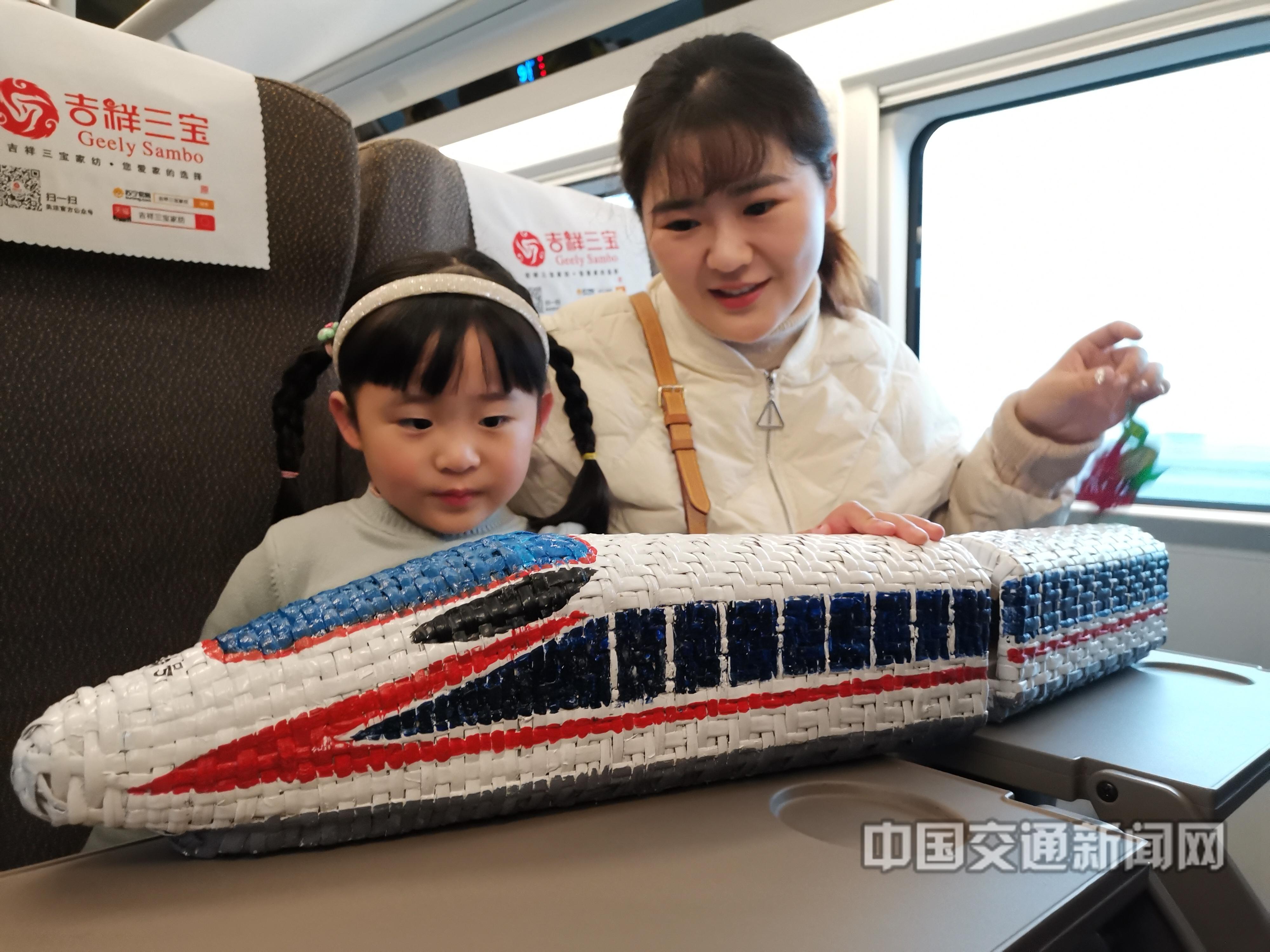 陆应果13818060268《阜阳民工潮变化》2019年12月1日是，阜阳西至上海虹桥的G7787次首班列车上，一对母女正在欣赏阜阳市阜南县的柳编等非物质文化遗产作品。 .jpg